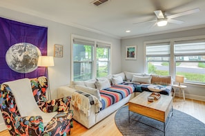 A modern living room with a sofa, a chair, a coffee table, and a ceiling fan. - Old Austin Vibes! Spacious Yard & Porch Near UT (Austin)