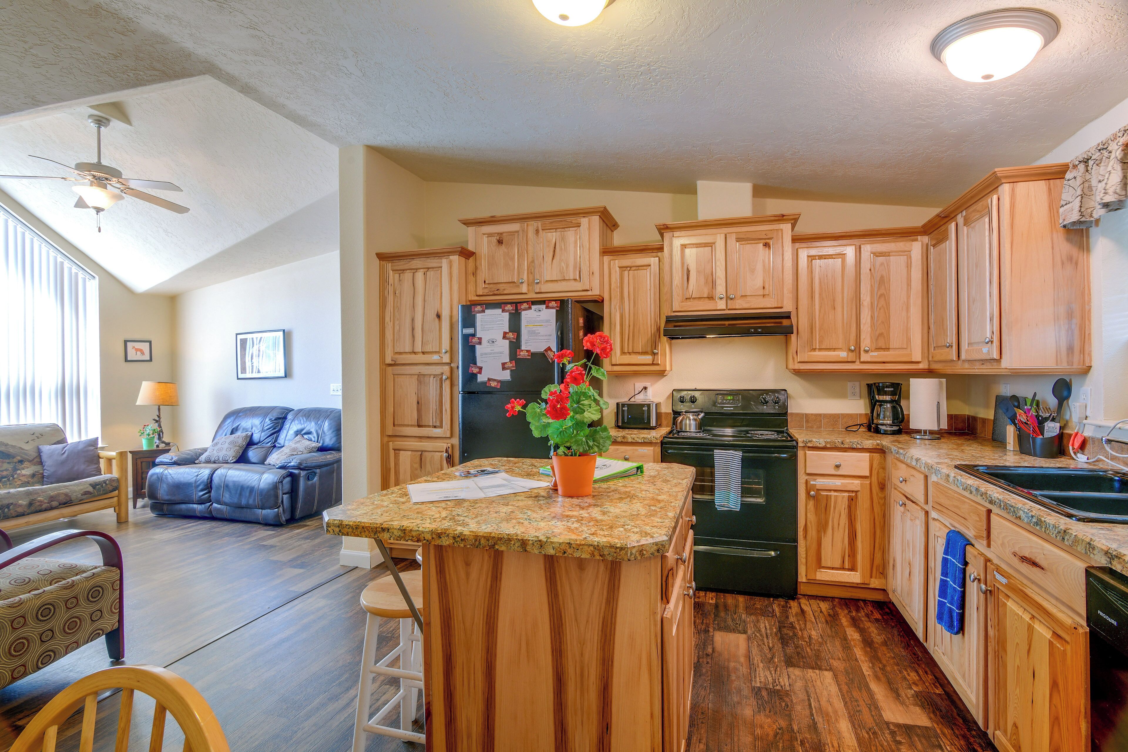A kitchen with wooden cabinets, a refrigerator, a stove, and a coffee maker.