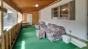 A covered outdoor area with a green carpet, wooden ceiling, a sofa set, a table, and a window. - 6 Blocks to Yellowstone NP: 'bison Home' w/ BBQ (West Yellowstone)