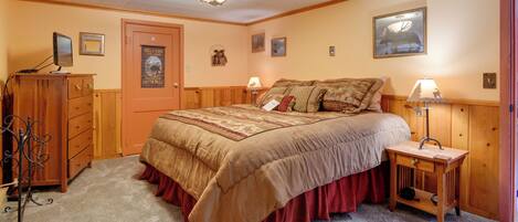 Un dormitorio con cama, cómoda, lámpara y adornos en la pared.