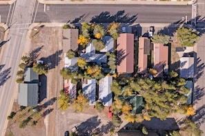 An aerial view of a residential area with houses, trees, and a road. - Gateway to Yellowstone! Cabin < 1 Mi to Nat'l Park (West Yellowstone)