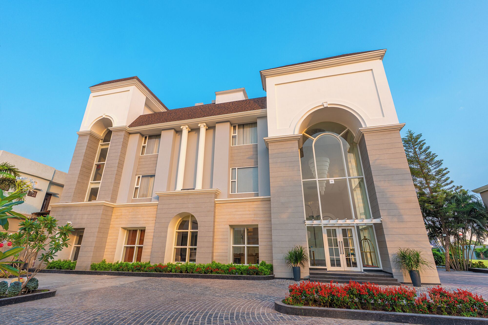 A multi-story hotel with a symmetrical facade, large arched windows, and a central entrance with a glass door.