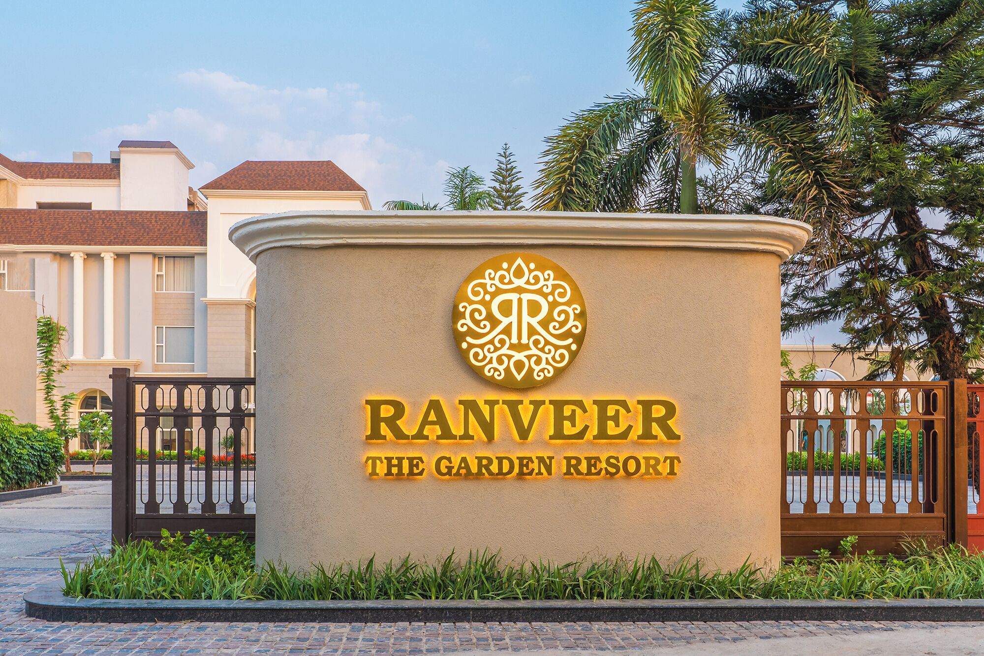 Ein Schild für Ranveer The Garden Resort mit beleuchtetem Logo und Schriftzug.