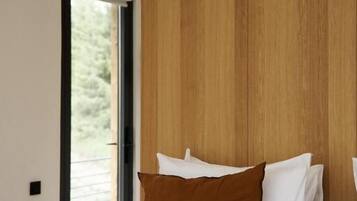 A bedroom with a bed, a window, and a wooden wall.