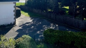 Ein Wohngebiet mit einem großen Baum, einem weißen Haus und Blick auf das Meer.