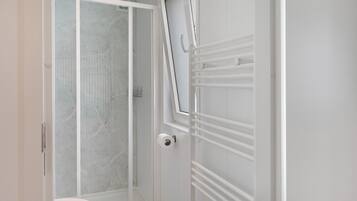 Ein Badezimmer mit Dusche, Toilette und Handtuchhalter.