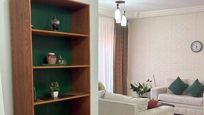 Un salon avec une bibliothèque en bois, un canapé et une table à manger.
