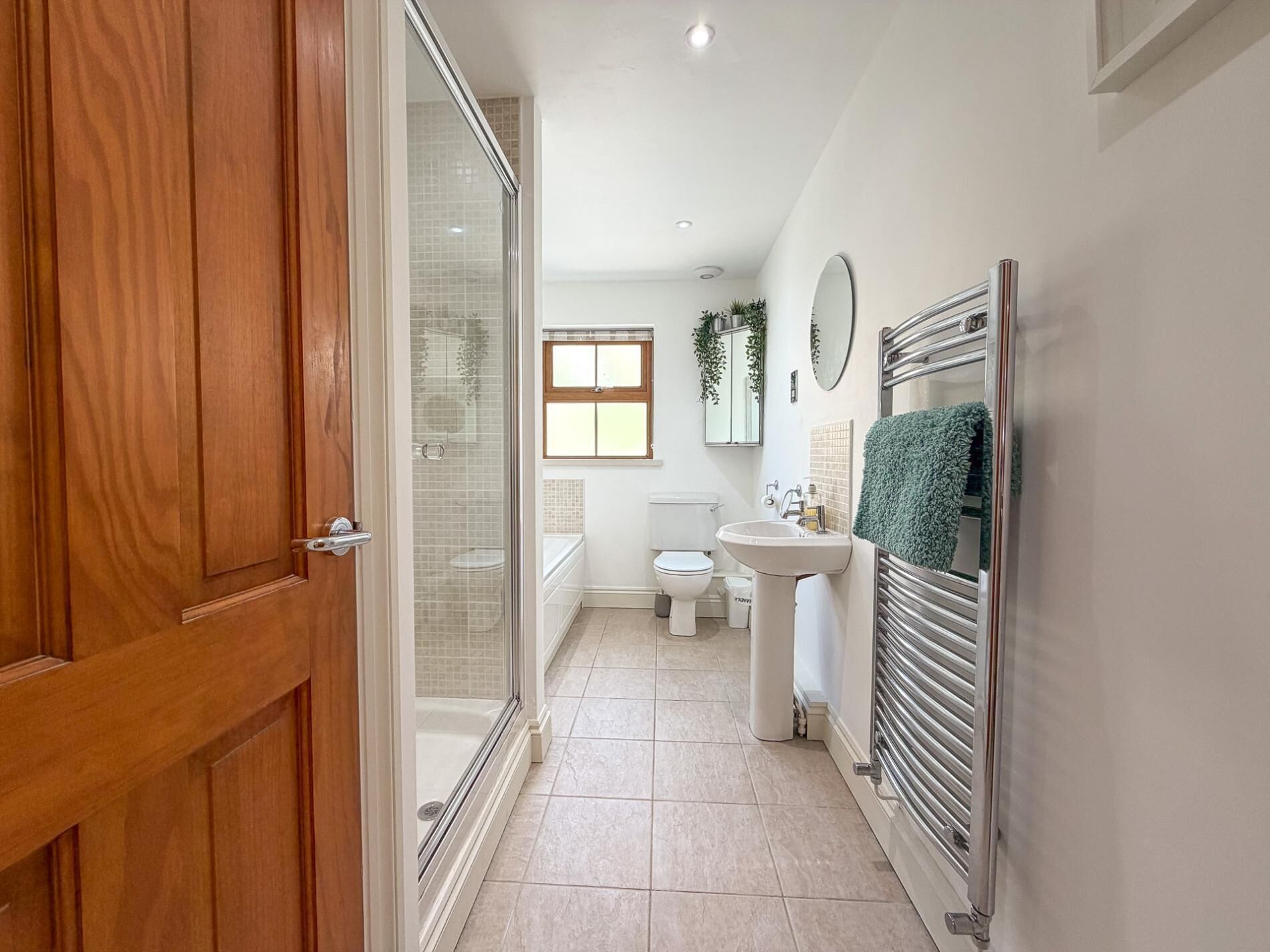 Une salle de bain avec une douche à parois de verre, des toilettes, un lavabo et un porte-serviettes.