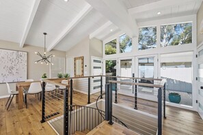 Un intérieur moderne avec un plancher en bois, des murs blancs et un escalier doté de rampes en métal.