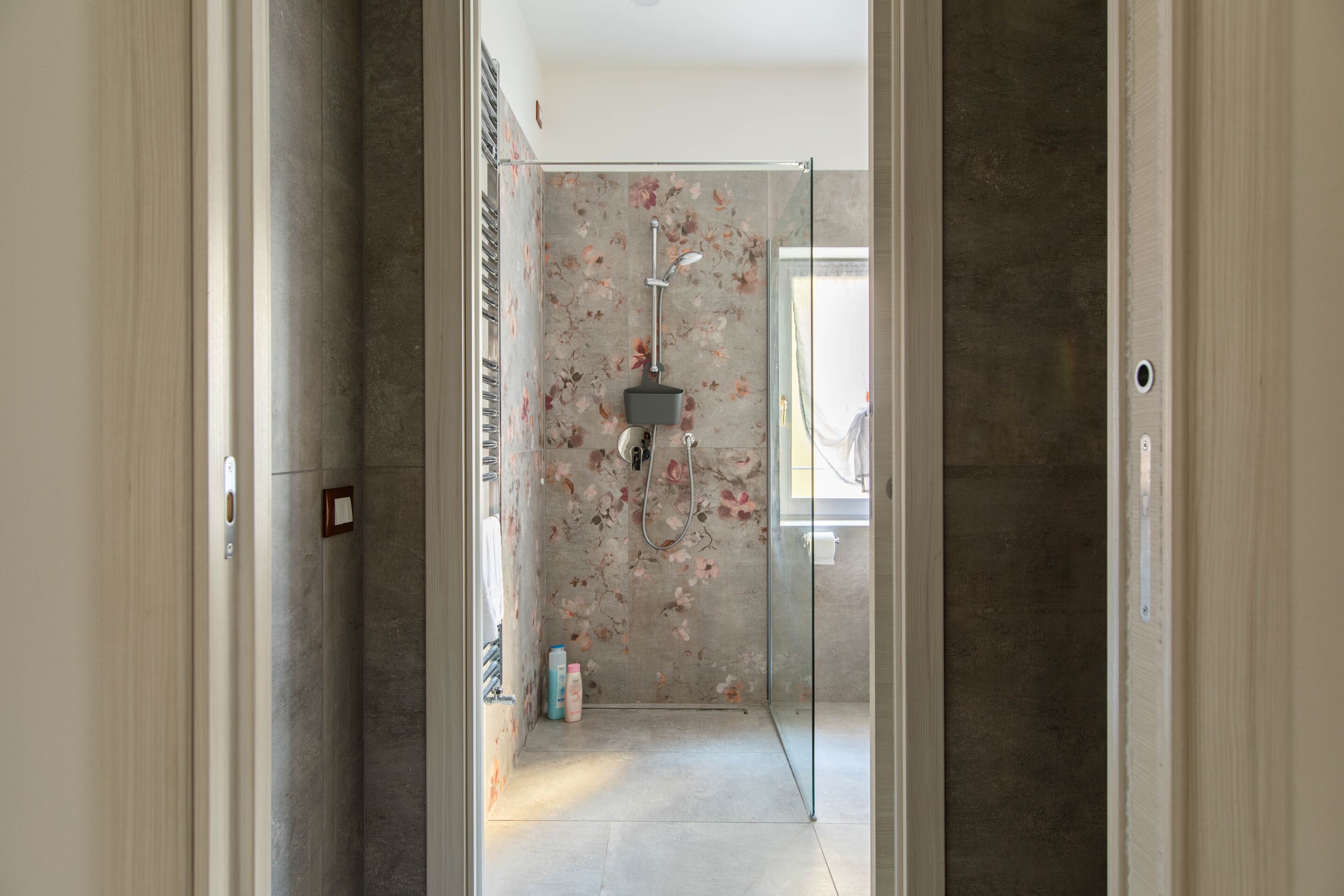 Une salle de bain moderne avec une douche, une porte en verre et un mur en marbre.