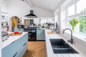 A modern kitchen with a central island, a built-in oven, a microwave, and a sink.