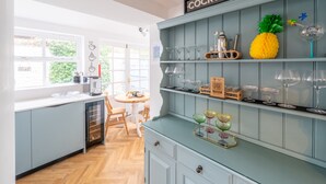 A kitchen with a light blue cabinet, a coffee machine, and a sign labeled 'COCKTAILS'. - Cliff Lane House, Cromer, Norfolk (Cromer)