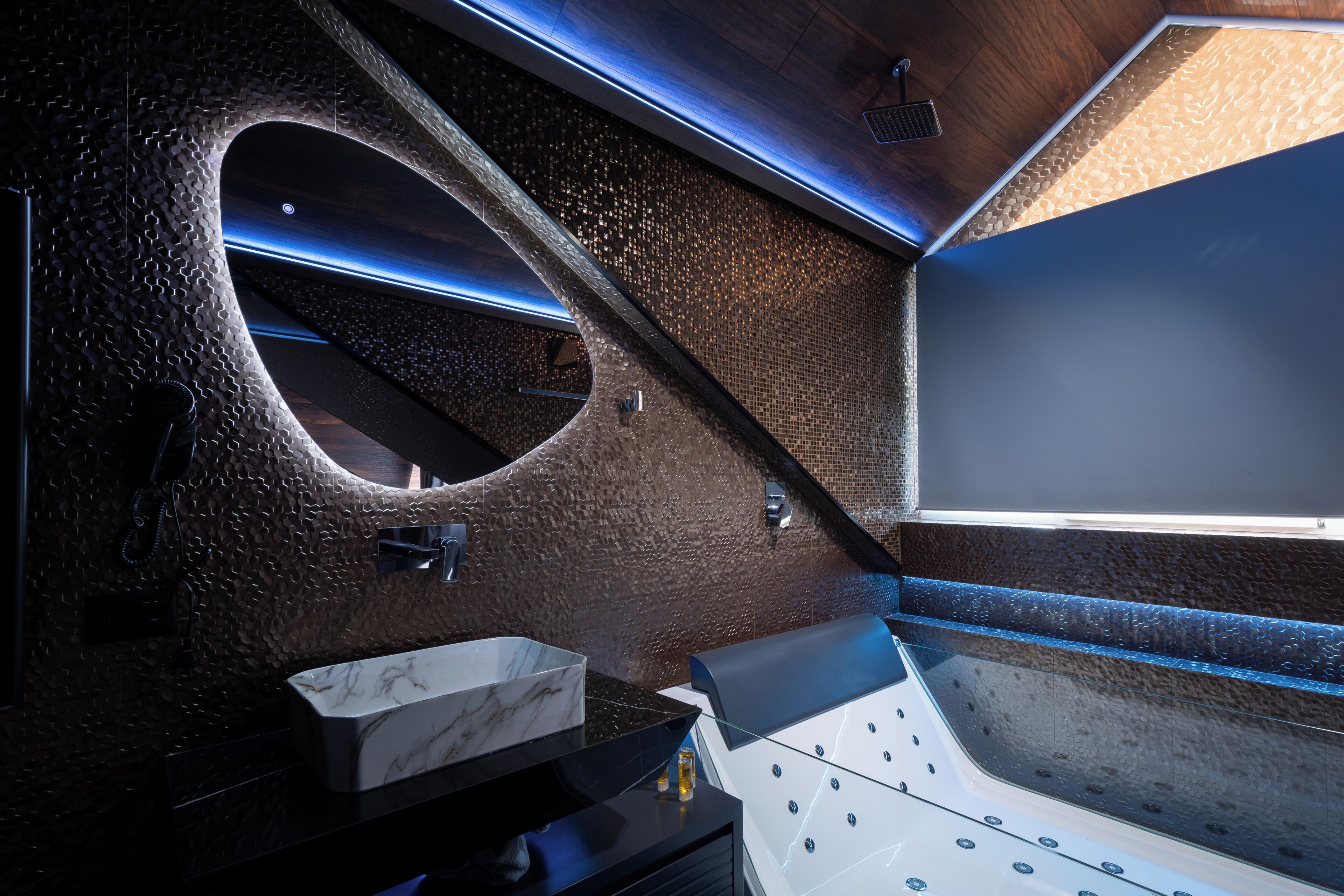 A modern bathroom with a marble sink, a bathtub, and a unique textured wall design.