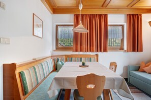 Un espace repas comprenant une table, des bancs et un canapé.