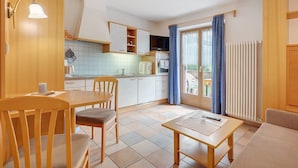Une cuisine moderne avec des meubles blancs, une table à manger et des chaises.