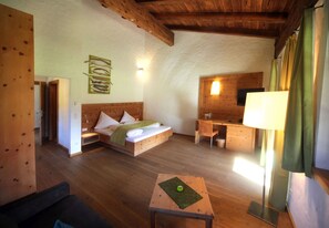 A room with a bed, a desk, a lamp, and a small table with a placemat. - Falkensteiner Camping Grubhof (Sankt Martin bei Lofer)