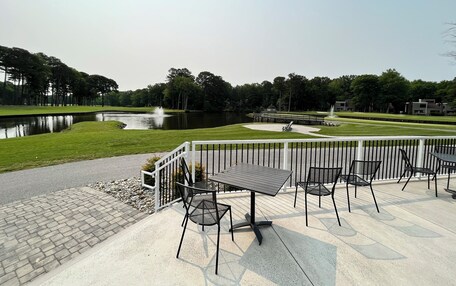 An outdoor patio area with a table and chairs, a small pond, and a fountain.
