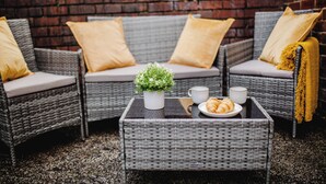 A wicker sofa set with cushions, a small table with a plant, a plate with croissants, and two cups. - Urban Haven Central Retreat | Free Parking | 16PPL (Sheffield)