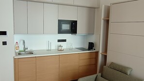 Une petite cuisine équipée d’un four à micro-ondes, d’un évier et d’une machine à café.