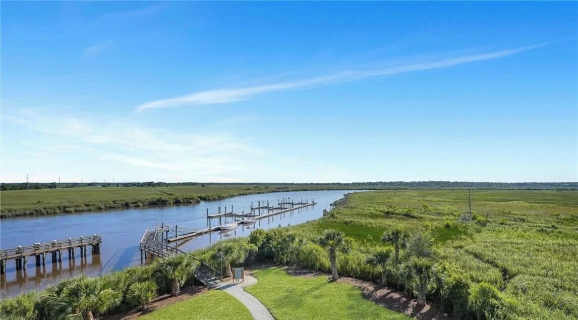 A river with a dock and a walking path alongside.