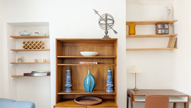 A room with a wooden cabinet, a desk, a chair, and shelves with decorative items. - Chichester City Centre Flat -  a flat that sleeps 2 guests  in 1 bedroom (Chichester)