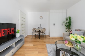 A modern living room with a TV, dining table, and a sofa. - Lumina Apart near a Large city Park (Warsaw)