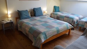 Une chambre avec deux lits, un bureau et une table de chevet.