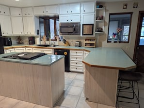 A kitchen with white cabinets, a microwave, a sink, and a dishwasher. - Spacious Sturgis Rally Rental 6 Bedroom Home (Spearfish)