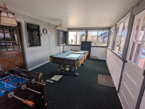 A pool table in a room with a window, a clock, and a door. - Spacious Sturgis Rally Rental 6 Bedroom Home (Spearfish)