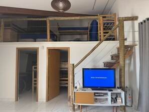 A loft bedroom with a TV, a desk, and a staircase. - Entire space: house in Igaratá, Brazil (Igaratá)