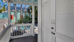 Ein überdachter Außenbereich mit Pool, Blick auf ein Grünhaus und einer geschlossenen Garagenzufahrt.