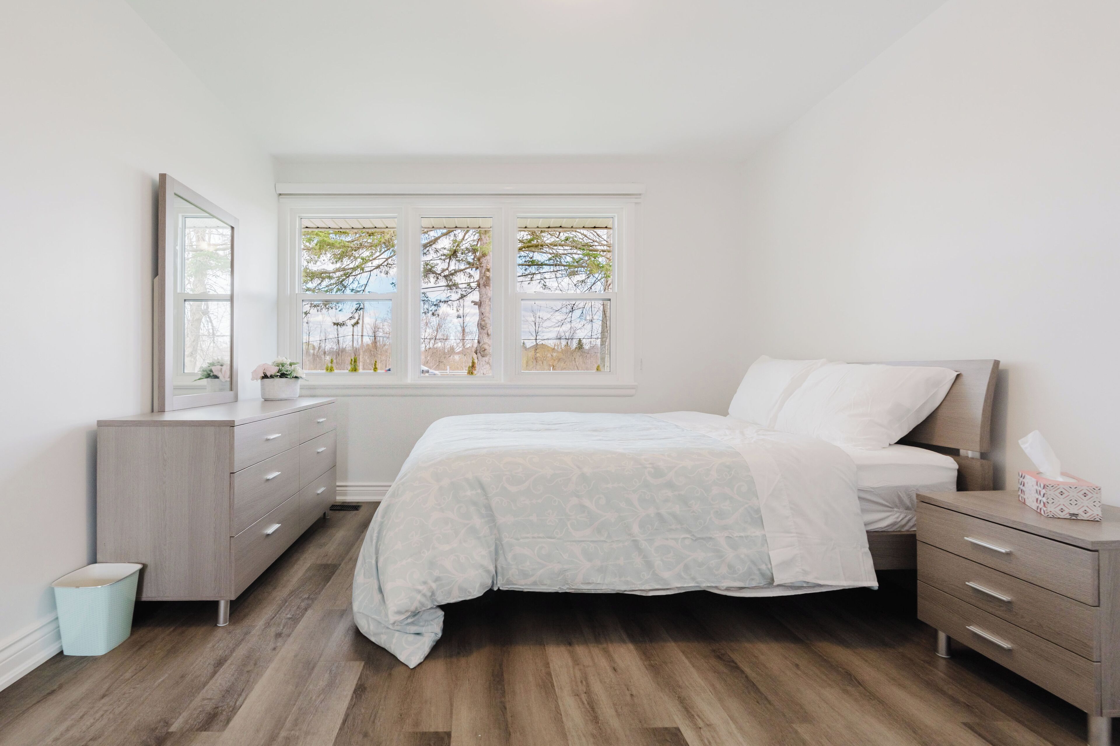 Un dormitorio con cama, cómoda y ventana.