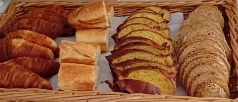 Uma bandeja de vime com pães variados.
