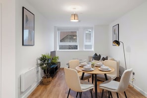 A modern dining area with a round table, chairs, and a potted plant. - City Point Aberdeen by Guestz (Aberdeen)