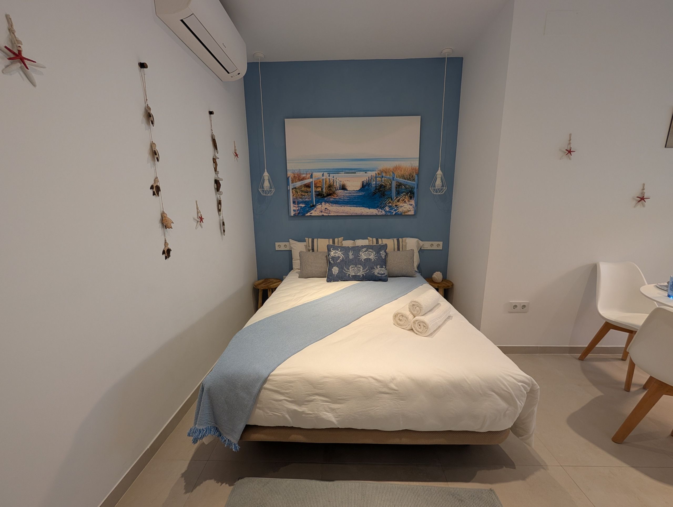 A bedroom with a bed, a desk, and a chair.