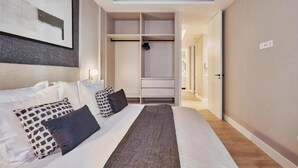 A hotel room with a bed, a walk-in closet, and a hallway leading to another room. - Spacious Group Apartment in the Heart of Madrid Near Plaza Mayor (Madrid)