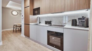 A modern kitchen with a built-in microwave, oven, and coffee maker. - Spacious Group Apartment in the Heart of Madrid Near Plaza Mayor (Madrid)