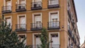 A multi-story building with balconies, a ground-level cafe, and a visible entrance. - Spacious Group Apartment in the Heart of Madrid Near Plaza Mayor (Madrid)