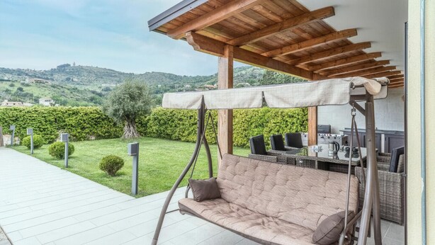 A patio with a swing chair, a dining area with outdoor furniture, and a view of the surrounding landscape. - Lara Residence - Agropoli (Agropoli)