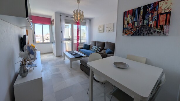 A modern living room with a sofa, dining table, and artwork on the wall. - 117 Livingtarifa Trebol (Tarifa)