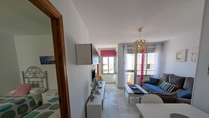 A bedroom with a bed, a bedside table, a dresser, and a window with curtains. - 117 Livingtarifa Trebol (Tarifa)