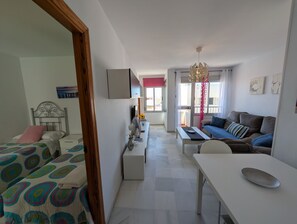 A bedroom with a bed, a bedside table, a dresser, and a window with curtains. - 117 Livingtarifa Trebol (Tarifa)