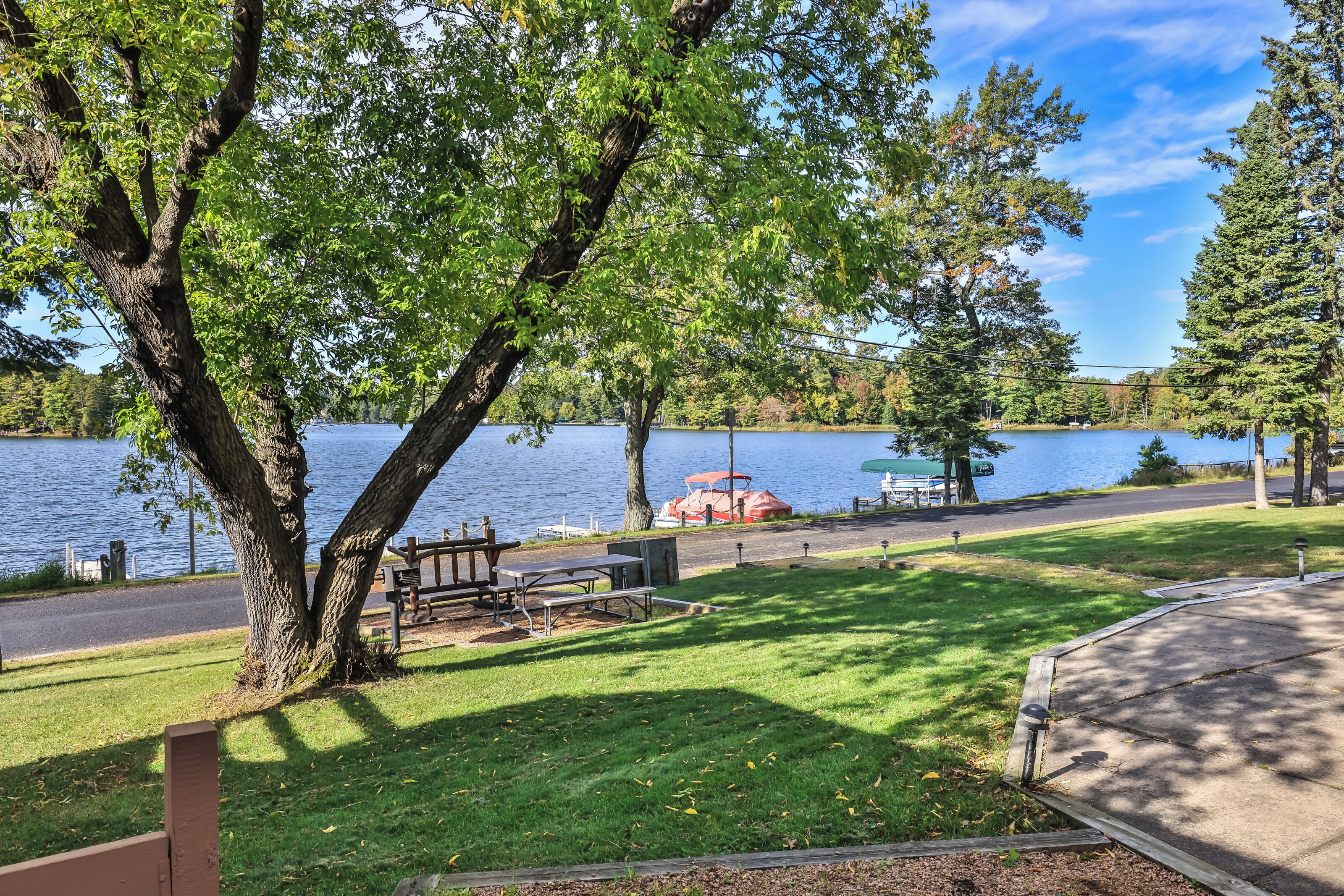 Un parc au bord du lac, équipé de tables de pique-nique, d’un espace abrité et d’un quai pour bateaux.