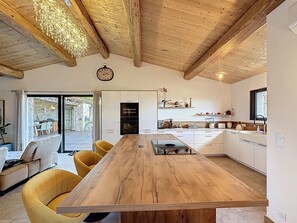 Eine moderne Küche mit einem Holztisch, gelben Stühlen und einer Uhr an der Wand.