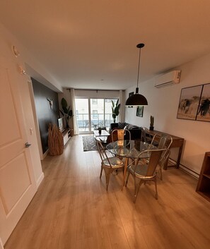 Un appartement moderne comprenant un coin repas, un salon et un balcon avec vue.
