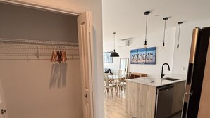 Eine moderne Küche mit Kochinsel, Pendelleuchten und einer Essecke mit Stühlen.