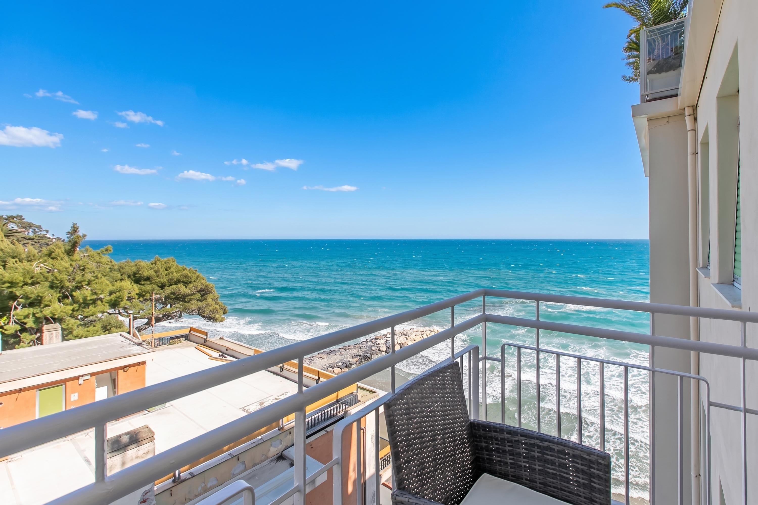 A balcony with a view of the sea and rocky coastline.