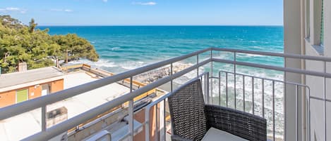 A balcony with a view of the sea and rocky coastline.