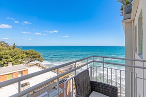 Ein Balkon mit Blick auf das Meer und die felsige Küste.