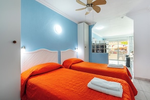 A hotel room with two beds, a ceiling fan, and a view of the outside. - Great Location Santa Maria Studio . Pool view.Fully refurbished.Air con. WIFI (Costa Adeje)
